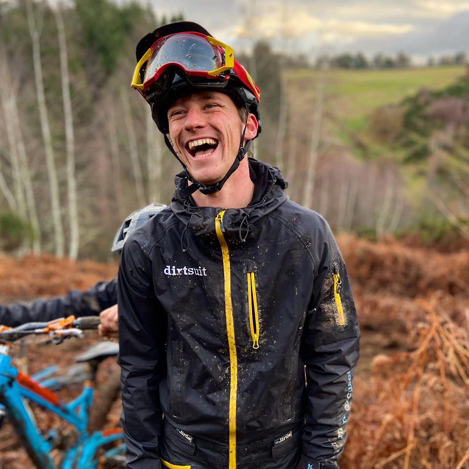 A muddied and happy mountainbiker wearing the dirtlej dirtsuit pro edition 